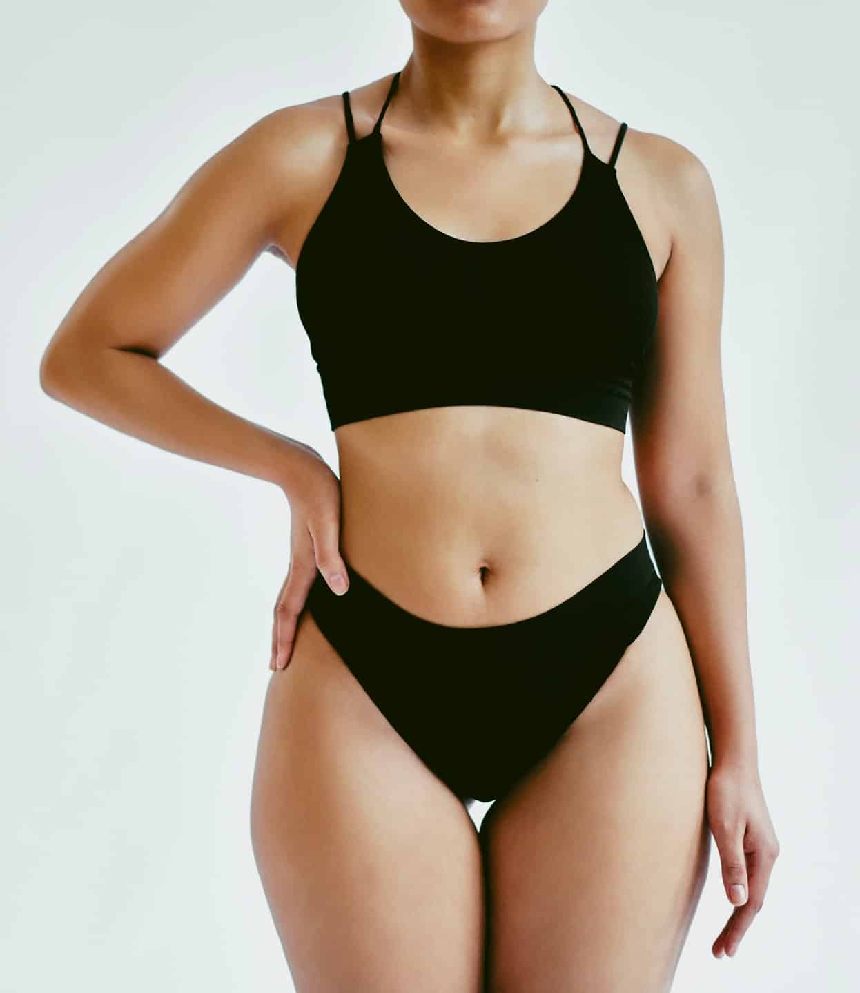 Model, bikini and studio for plus size photoshoot in fashion, magazine or blog on the web. Woman, body positivity and lingerie with grey background for underwear, marketing and advertising commercial