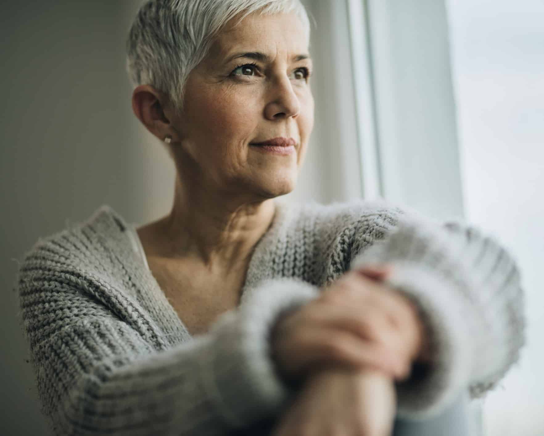 Portrait of beautiful mature woman relaxing by the window.