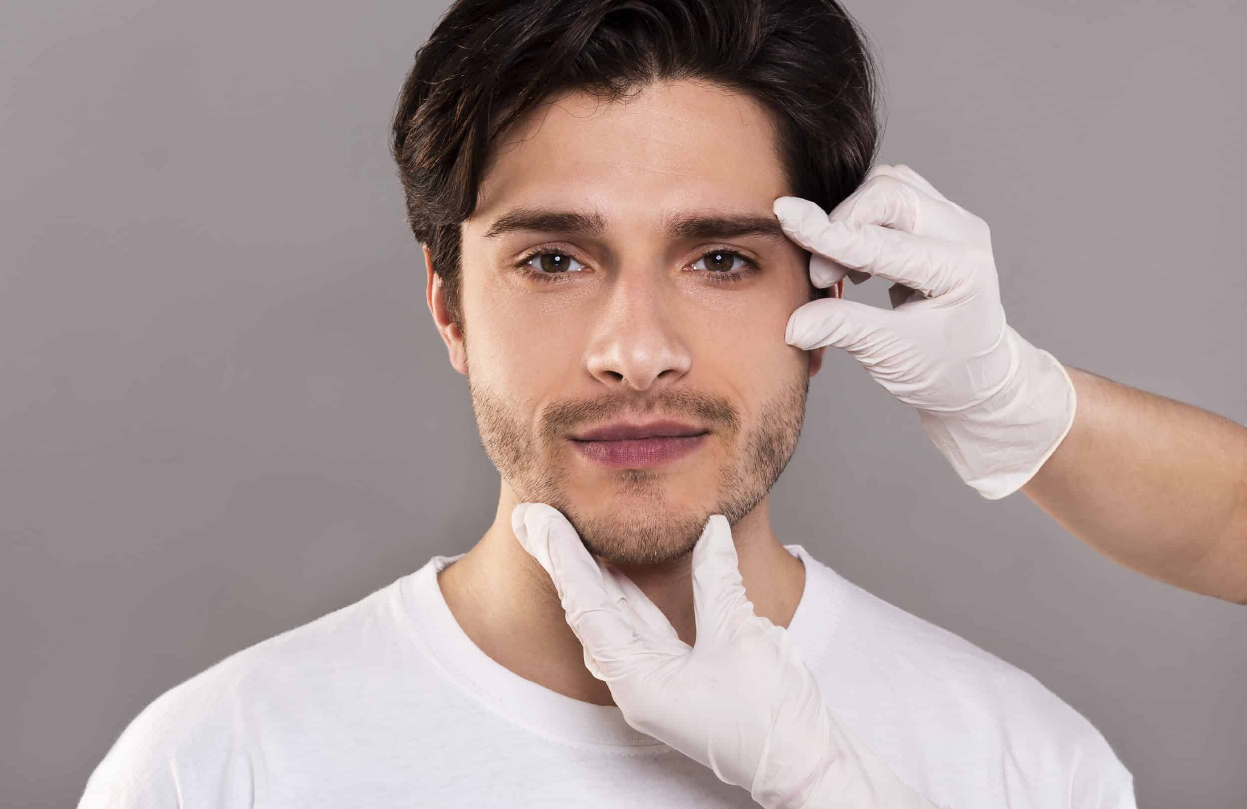 Beautician massaging her face of young handsome man