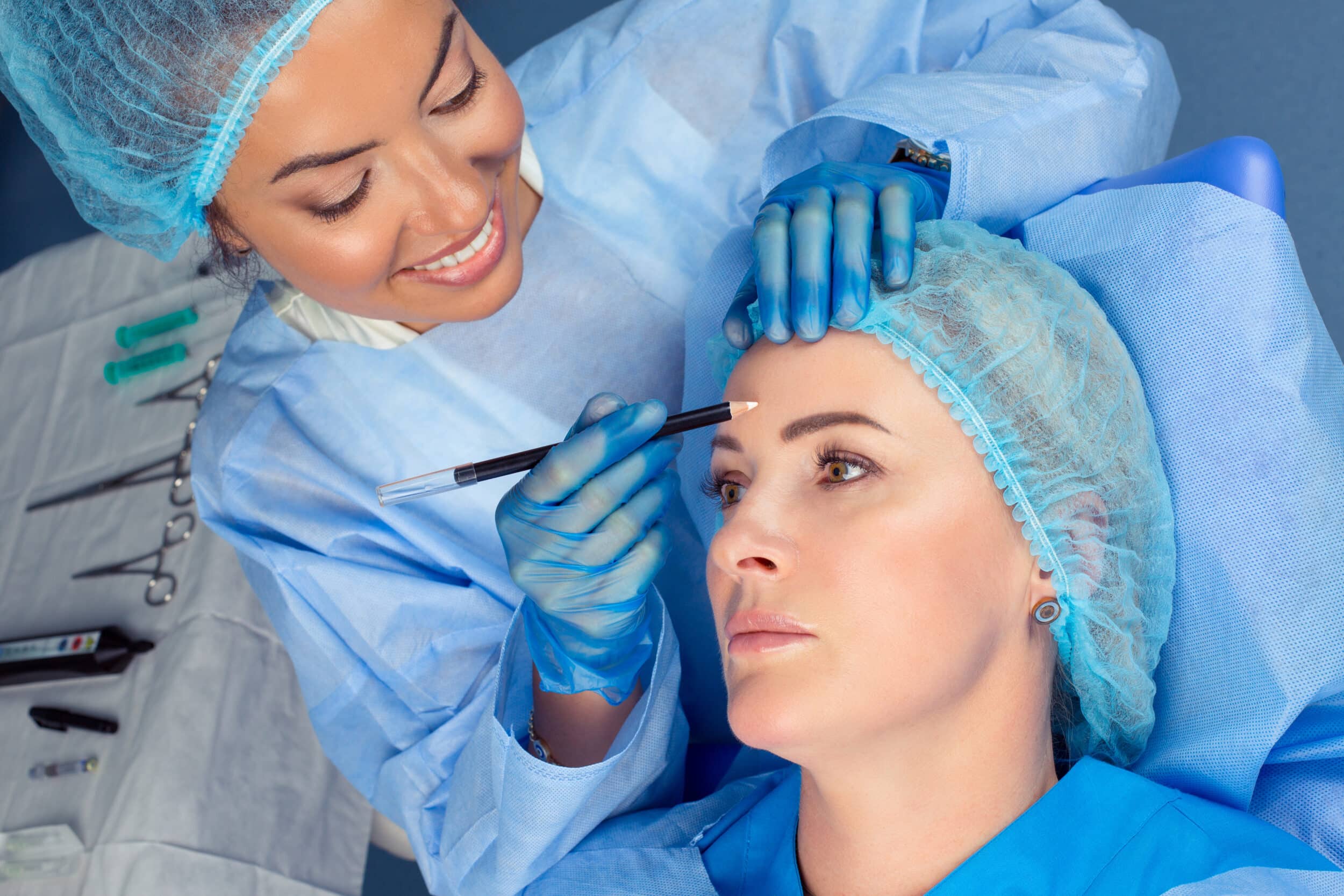 doctor woman about to draw lift line on patient forehead with penci