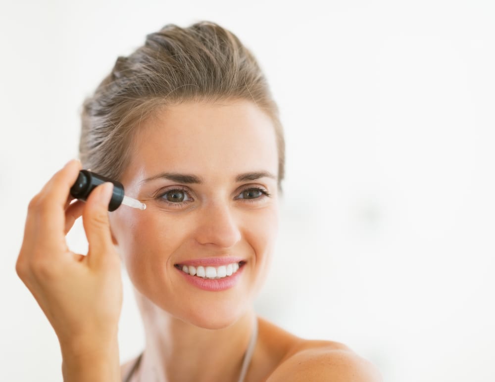 woman applying vitamin c serum