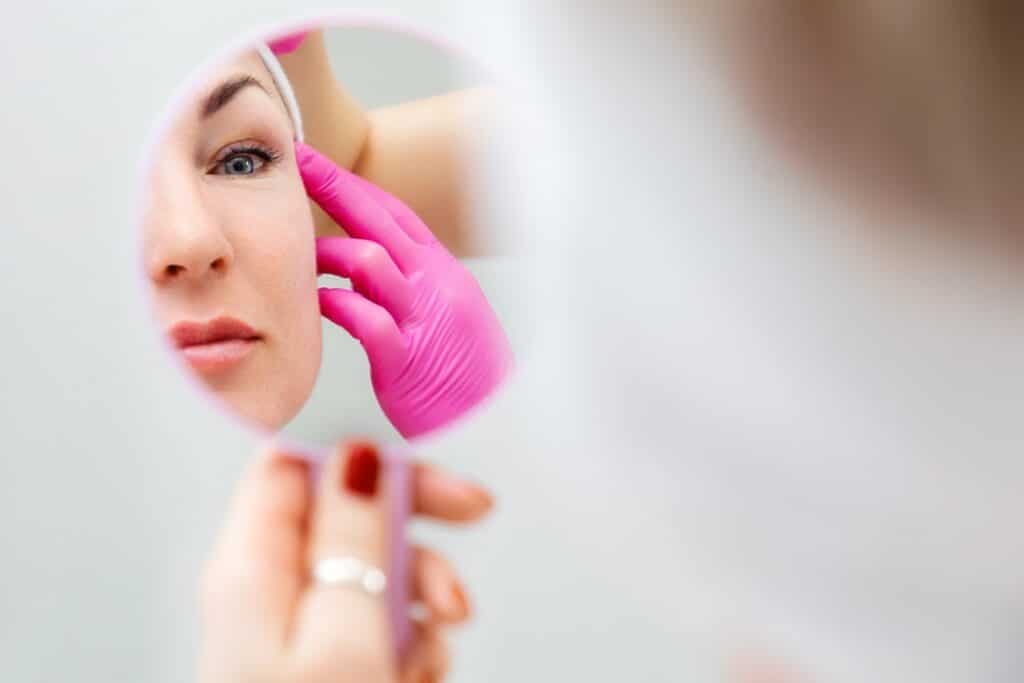 Woman looking in the mirror at facelift results in Salt Lake City, UT